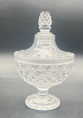 clear glass lidded jar with a decorative design on the top