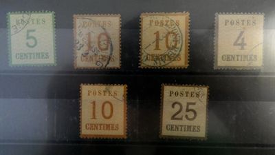 cinq timbres différents exposés dans une vitrine