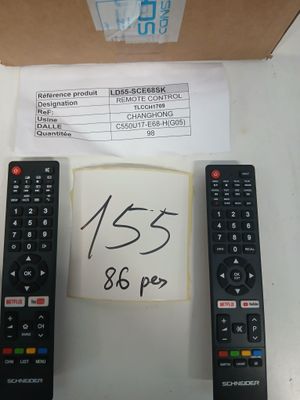 trois télécommandes posées sur une table à côté d'un carton