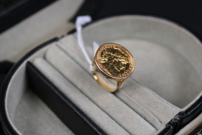 a ring with a gold coin in it in a case