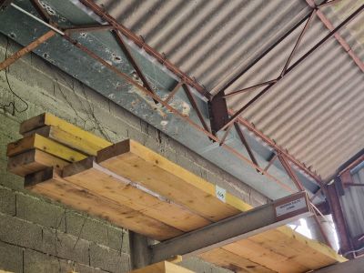 un toit métallique sur lequel reposent de nombreuses poutres en bois