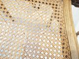 a close up of a wicker chair with a wooden seat