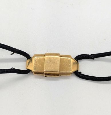 une photo d'un bracelet plaqué or avec un cordon noir