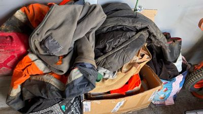 a pile of clothes and a guitar in a box
