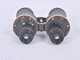 an old pair of binoculars sitting on top of a white surface