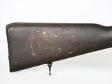 an old gun is sitting on a stand on a white surface