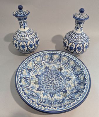 deux vases bleus et blancs et une assiette posés sur une table