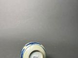 an old blue and white vase sitting on top of a table