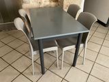a table and four chairs that are sitting on the tile floor