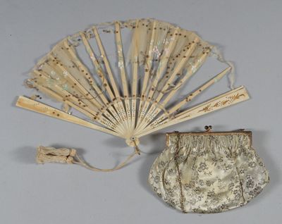 a small purse and a fan on a table