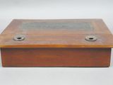 an old wooden box with a metal plate on top of it