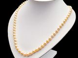 un collier blanc orné de perles posé sur un présentoir pour mannequin
