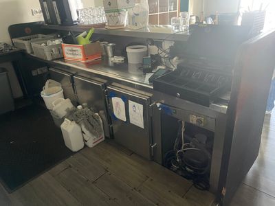 une cuisine équipée d'une cuisinière, d'un évier et d'un réfrigérateur