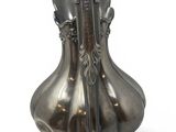 a silver vase on a white surface with a white background