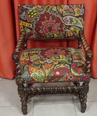 an old chair with a colorful upholstered seat
