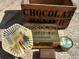 une personne tenant un éventail en papier à côté d'une boîte de chocolats