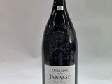 the bottle of red wine is sitting on a white surface