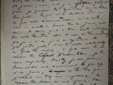 an old handwritten letter on a piece of paper sitting on top of a table