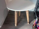 a small white table with a small stool on it