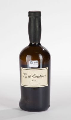 une bouteille de vin avec une étiquette, posée sur une surface blanche