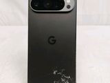 a close up of the back of a black phone with a cracked screen