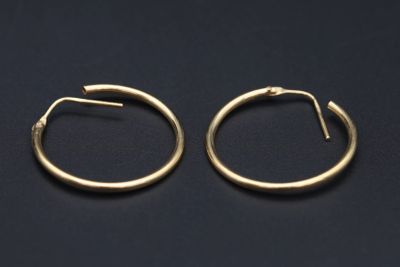 une paire de boucles d'oreilles en or sur fond noir