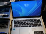 Plusieurs ordinateurs portables sont posés sur une table, le couvercle ouvert.