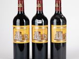 trois bouteilles de vin rouge posées l'une à côté de l'autre sur une surface blanche