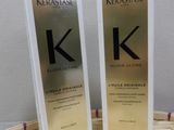 deux flacons de Kérastase posés sur une table, avec un panier en arrière-plan
