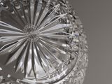someone is holding a clear glass bowl in their hand