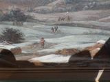 une photo d'un tableau accroché au mur derrière une fenêtre