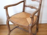 a wooden chair with a woven seat on a hard wood floor