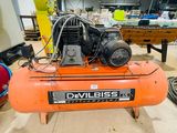 an orange air compressor sitting on top of a table in a room