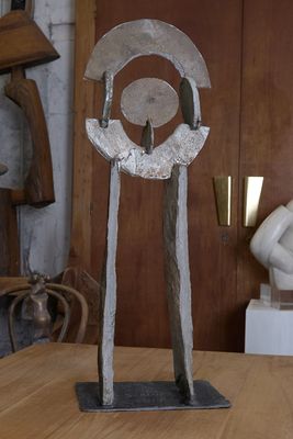 une sculpture en métal posée sur une table en bois dans une pièce