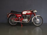 une moto rouge et blanche garée dans un garage