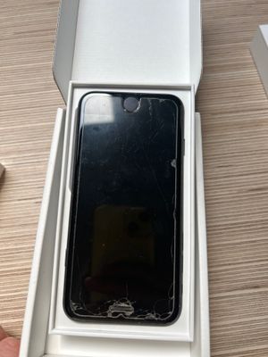 Quelqu'un tient sur une table une boîte contenant un téléphone.
