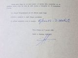 an old document with a handwritten letter on it sitting on top of a table