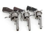 three old revolvers sitting on top of each other on a white surface