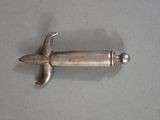 a small silver object on a gray surface