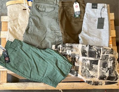 une caisse en bois remplie de vêtements pour hommes de toutes sortes