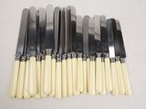 six knives are lined up on top of each other on a table