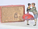 figurine représentant un homme et une femme tenant un parapluie rouge à côté d'une boîte