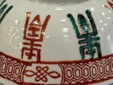 a white bowl with red and green designs on it