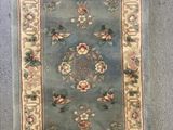 une photo d'un tapis bleu orné d'un motif floral