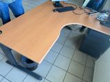 a man standing next to a desk with a computer on it