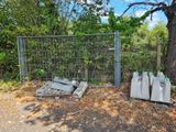 a fence that has a bunch of trash on the ground