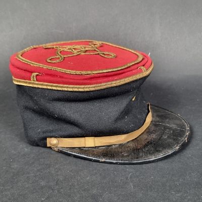 un chapeau noir orné d'un ruban rouge et doré