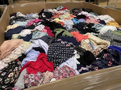 une boîte en carton remplie de nombreux vêtements dans un entrepôt