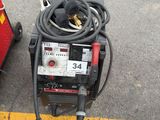 a welding machine sitting on the ground next to a pallet