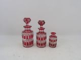 trois vases en verre rouge placés les uns à côté des autres